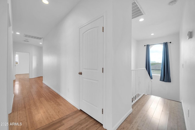 hallway featuring wood-type flooring, visible vents, and recessed lighting