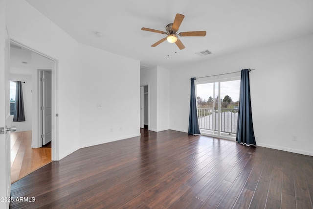 empty room with baseboards, visible vents, ceiling fan, and wood finished floors