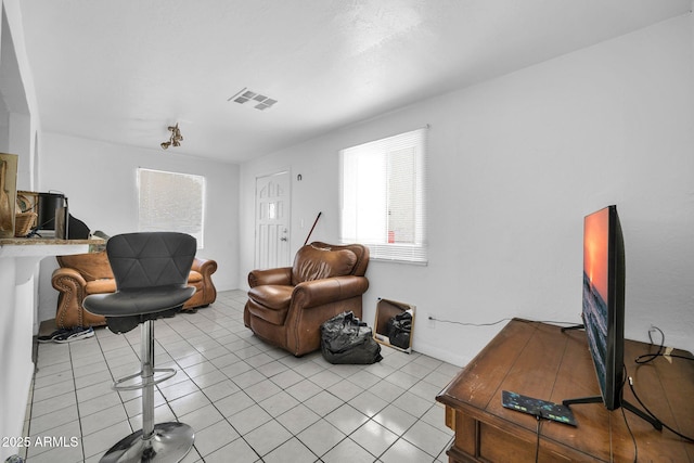 living area with visible vents and light tile patterned flooring