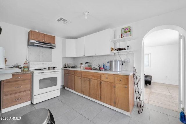 kitchen with arched walkways, open shelves, white range with electric cooktop, visible vents, and under cabinet range hood