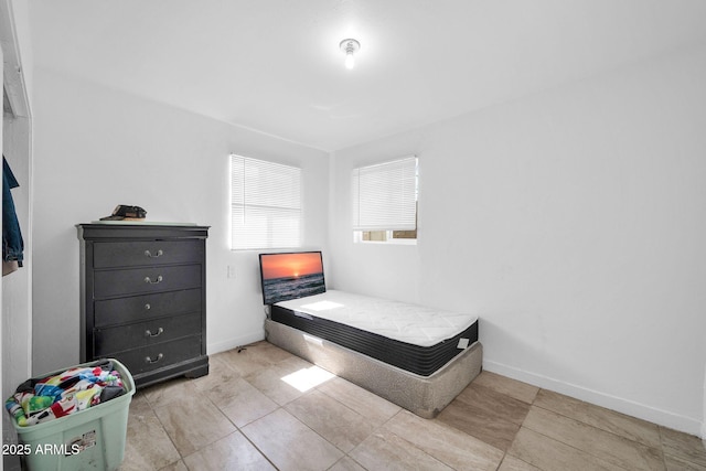 bedroom featuring tile patterned flooring and baseboards