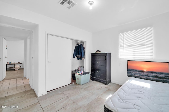 bedroom featuring a closet, visible vents, and baseboards