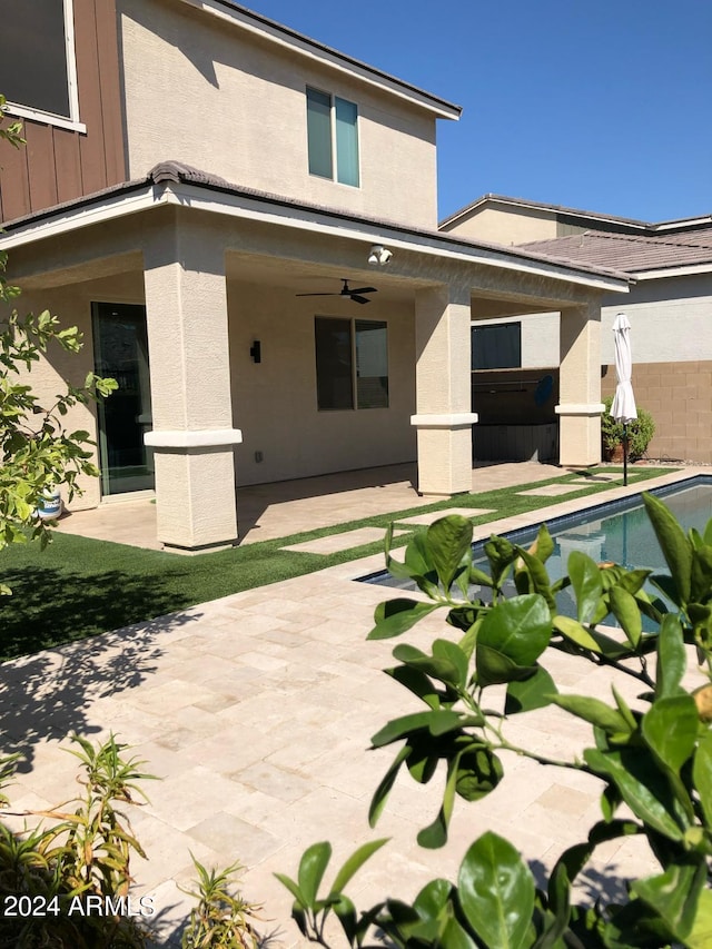 rear view of property featuring ceiling fan and a patio area