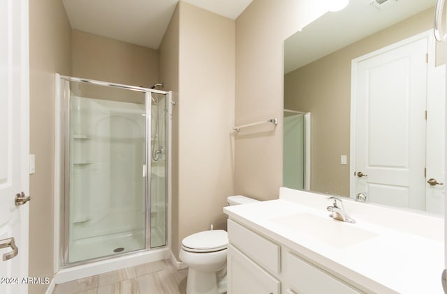 bathroom featuring vanity, toilet, tile patterned floors, and a shower with door