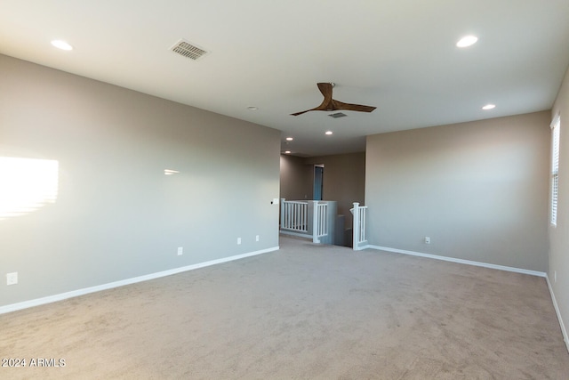 carpeted spare room featuring ceiling fan