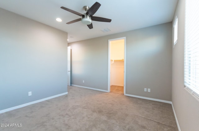 empty room featuring ceiling fan and light carpet