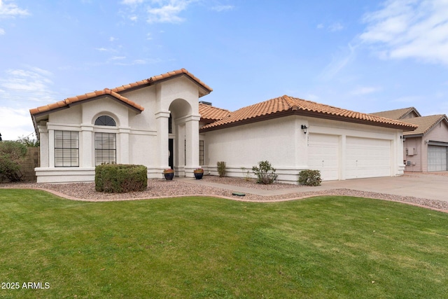 mediterranean / spanish house featuring a tile roof, a front yard, stucco siding, driveway, and an attached garage