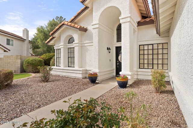 entrance to property with stucco siding and a tiled roof