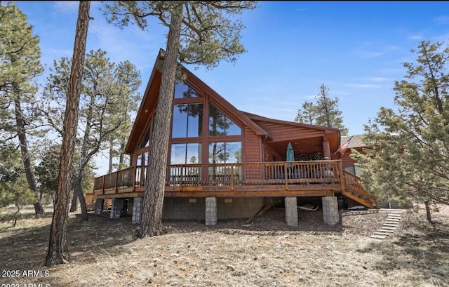 rear view of property with stairs and a deck