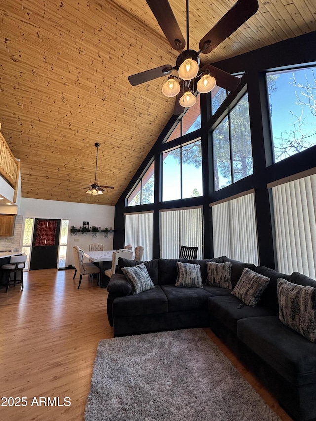 living area featuring wooden ceiling, light wood-style flooring, and a towering ceiling