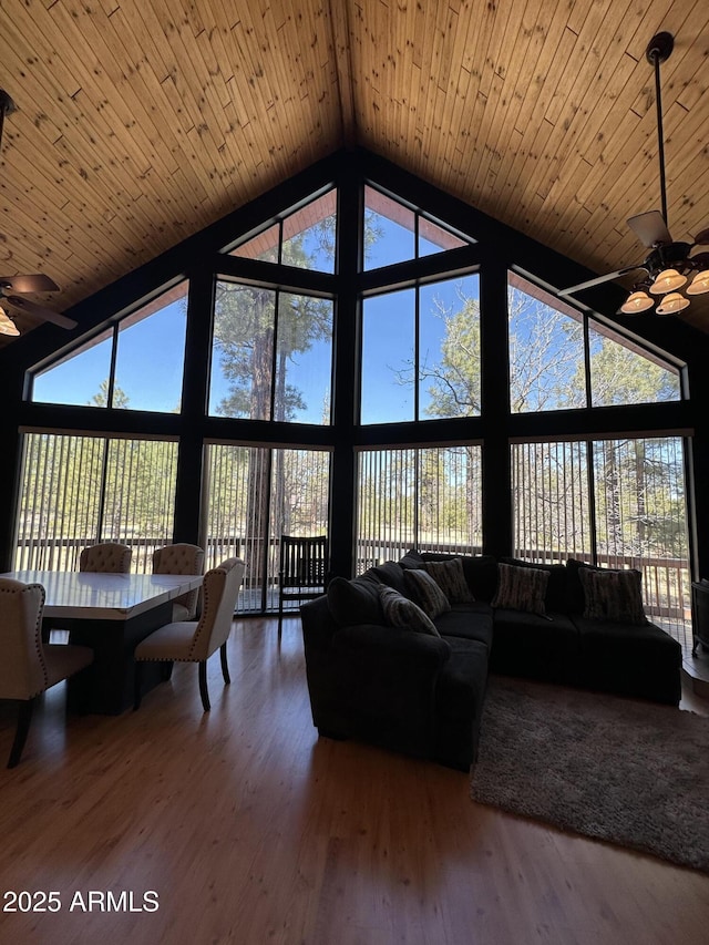 sunroom featuring wooden ceiling, a ceiling fan, and vaulted ceiling