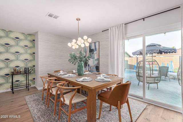 dining area with a chandelier and light hardwood / wood-style flooring