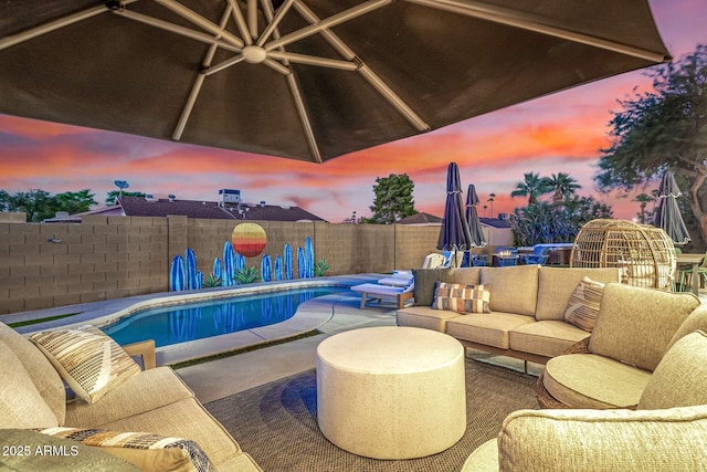 patio terrace at dusk featuring an outdoor living space and a fenced in pool