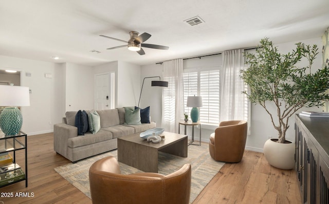 living room with ceiling fan and light hardwood / wood-style flooring