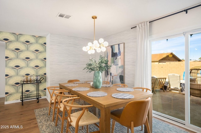 dining room with hardwood / wood-style floors and an inviting chandelier