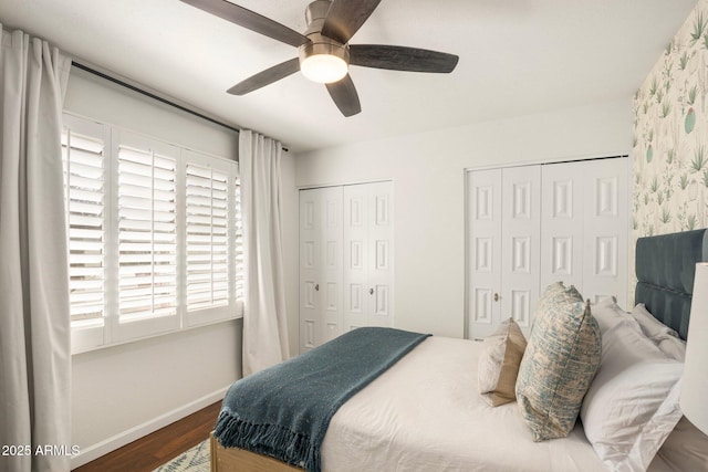 bedroom with multiple closets, ceiling fan, and dark wood-type flooring