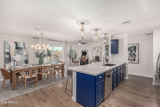 kitchen featuring blue cabinets, tasteful backsplash, sink, stainless steel dishwasher, and kitchen peninsula