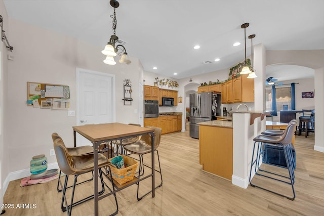 10613 E Knowles Ave, Mesa, AZ 85209 - kitchen featuring arched walkways, appliances with stainless steel finishes, a peninsula, light wood finished floors, and recessed lighting