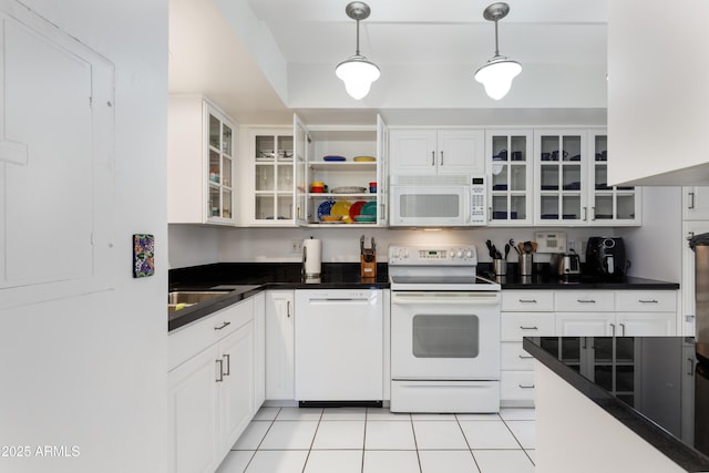 kitchen with light tile patterned floors, white appliances, dark countertops, and white cabinets