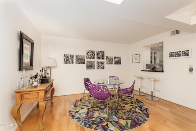 dining area with visible vents and wood finished floors