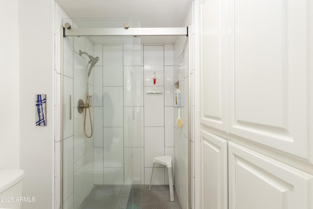 bathroom with a shower stall and toilet