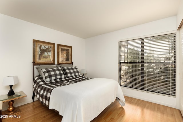 bedroom featuring baseboards and wood finished floors