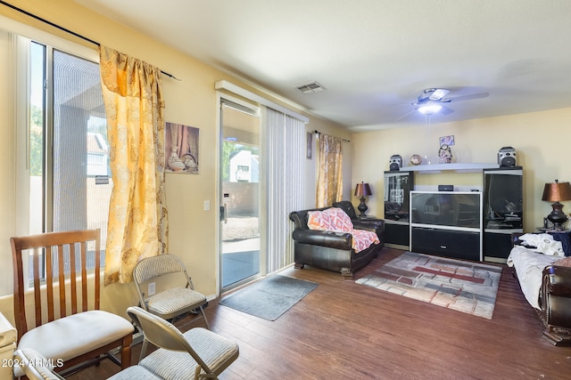 living area featuring ceiling fan and dark wood-type flooring