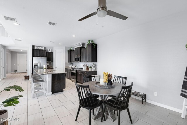 dining area with ceiling fan and sink