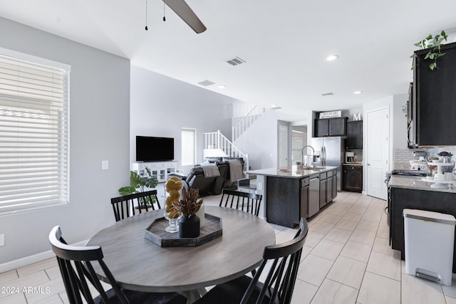 tiled dining room featuring ceiling fan and sink