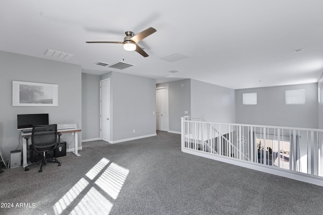 unfurnished office with ceiling fan and dark carpet