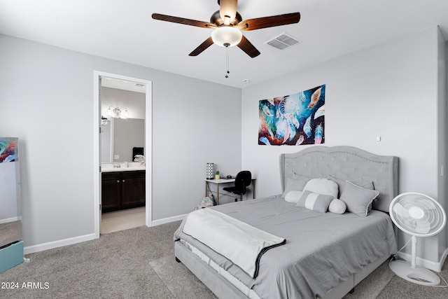 carpeted bedroom with ensuite bath and ceiling fan