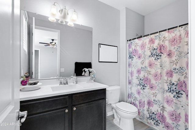 bathroom featuring vanity, toilet, ceiling fan, and curtained shower