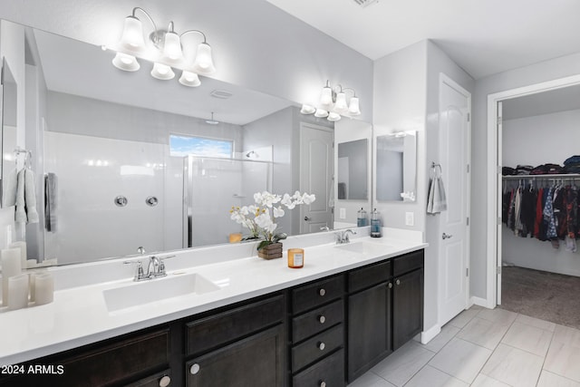 bathroom featuring tile patterned floors, a shower with door, and vanity