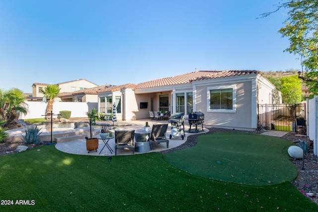 rear view of house featuring a lawn and a patio area