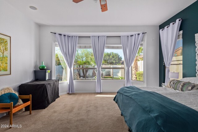 carpeted bedroom with multiple windows and ceiling fan