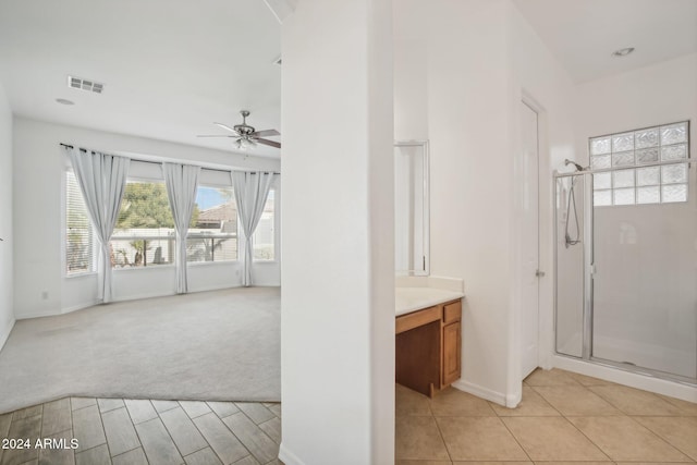 bathroom featuring tile patterned flooring, vanity, ceiling fan, and a shower with shower door