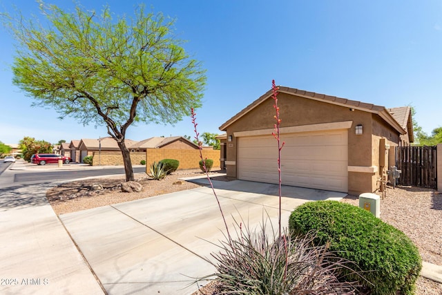 exterior space with fence, stucco siding, and concrete driveway