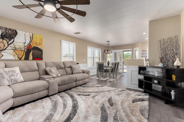 living area with visible vents, a textured ceiling, recessed lighting, wood finished floors, and ceiling fan with notable chandelier