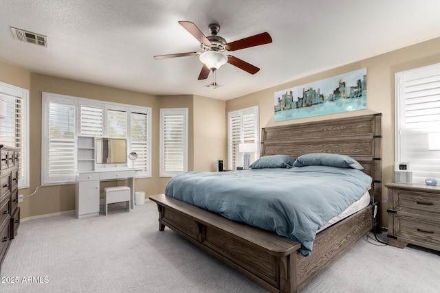bedroom featuring light carpet, baseboards, a ceiling fan, and visible vents