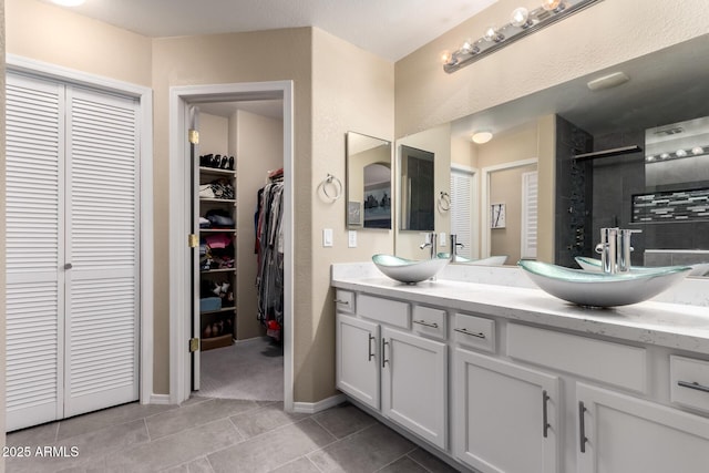 full bath with a shower stall, tile patterned floors, double vanity, and a sink