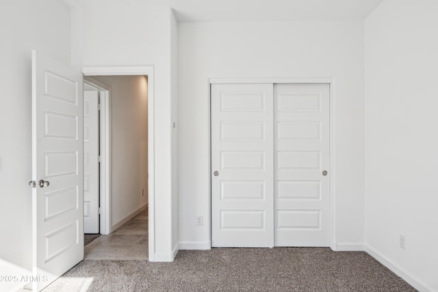 unfurnished bedroom featuring light carpet and a closet