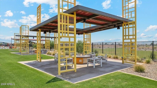 view of playground with an outdoor fire pit, a patio area, and a lawn