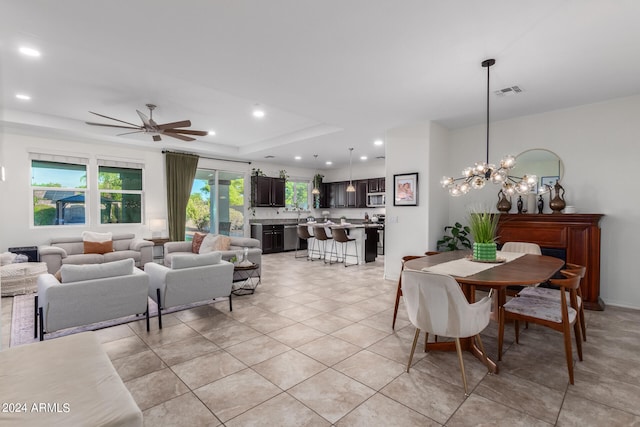 tiled dining space with ceiling fan with notable chandelier