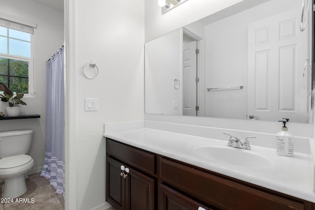 bathroom with tile patterned flooring, vanity, and toilet