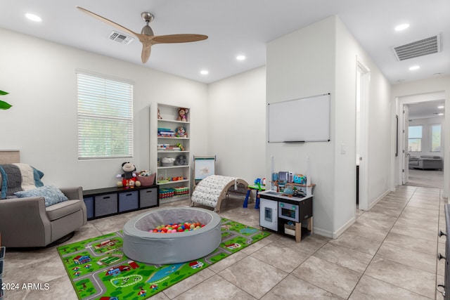 game room with light tile patterned floors, ceiling fan, and a healthy amount of sunlight