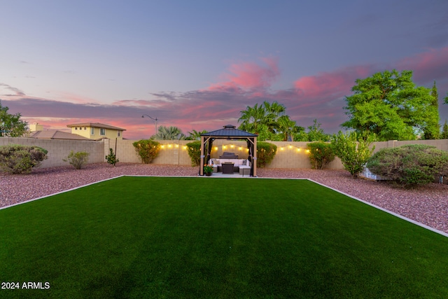 yard at dusk featuring a gazebo and a patio area