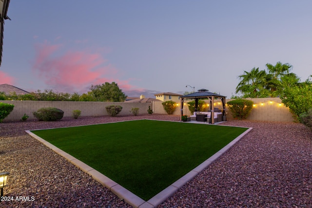 yard at dusk featuring a patio and a gazebo