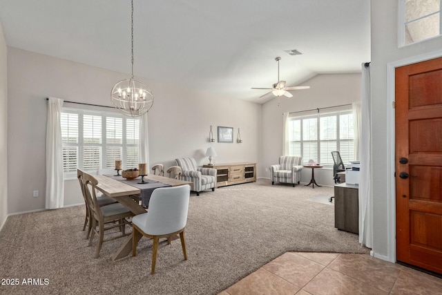 carpeted dining space with ceiling fan with notable chandelier and vaulted ceiling