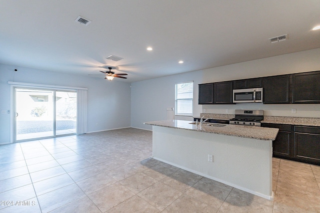 kitchen featuring appliances with stainless steel finishes, a wealth of natural light, a kitchen island with sink, and sink