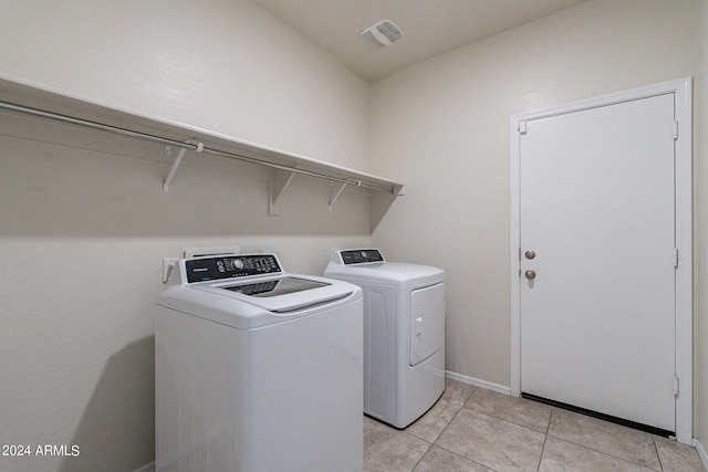 clothes washing area featuring independent washer and dryer and light tile patterned floors